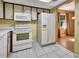 Kitchen with white appliances and wood cabinets, open to dining area at 41 Villa Villar Ct # 41, Deland, FL 32724