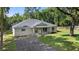 Single-story house with a gravel driveway and lush landscaping at 1650 Caroline Dr, Pierson, FL 32180