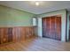 Light-filled bedroom with wood-paneled walls, built-in closet, and laminate flooring at 121 Willow Bend Ln, Ormond Beach, FL 32174