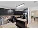 Spacious kitchen with island, dark cabinetry, and granite countertops at 968 Springs Landing Dr, Deltona, FL 32725