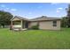 Tan house exterior with covered patio and large backyard at 968 Springs Landing Dr, Deltona, FL 32725