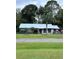 Single story home with metal roof, fenced yard, and mature trees at 24008 Ermine Rd, Astor, FL 32102