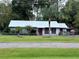 Single story home with metal roof and fenced yard at 24008 Ermine Rd, Astor, FL 32102