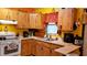 Bright kitchen featuring wood cabinets, white appliances, and a corner sink at 24008 Ermine Rd, Astor, FL 32102