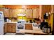 Galley kitchen with wood cabinets, white appliances, and ample counter space at 24008 Ermine Rd, Astor, FL 32102