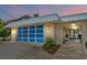 Contemporary home's entry with blue garage door and stone walkway at 717 Ocean Shore Blvd, Ormond Beach, FL 32176