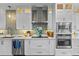 Modern kitchen with white cabinets, stainless steel appliances, and light gray tile at 717 Ocean Shore Blvd, Ormond Beach, FL 32176