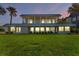 Oceanfront home featuring expansive windows and a spacious lawn at 717 Ocean Shore Blvd, Ormond Beach, FL 32176