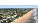 Wide aerial showcasing beachfront property and coastline at 717 Ocean Shore Blvd, Ormond Beach, FL 32176