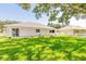 Spacious backyard with grassy lawn, mature trees, and a white picket fence at 4088 Clock Tower Dr, Port Orange, FL 32129