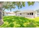Spacious backyard with grassy lawn, mature trees, and a white picket fence at 4088 Clock Tower Dr, Port Orange, FL 32129