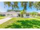 White house with carport, palm trees, and manicured lawn at 4088 Clock Tower Dr, Port Orange, FL 32129