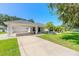 Front view of a single-story house with a carport and a palm tree at 4088 Clock Tower Dr, Port Orange, FL 32129