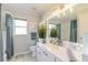 Clean bathroom with teal accents and a large vanity mirror at 4088 Clock Tower Dr, Port Orange, FL 32129
