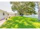 Spacious backyard with grassy lawn, mature trees, and a white picket fence at 4088 Clock Tower Dr, Port Orange, FL 32129