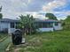 Home's backyard with grill and tropical plants at 401 Cherry St, South Daytona, FL 32119