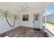 Screened porch with tile floor, ceiling fan, and painted palm trees at 1106 Carvello Dr, The Villages, FL 32162