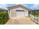 White single story home with attached garage and white picket fence at 1106 Carvello Dr, The Villages, FL 32162