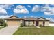 Tan house with a two-car garage and landscaped lawn at 3171 Utah Dr, Deltona, FL 32738