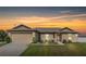House exterior at dusk, two-car garage, landscaped lawn at 3171 Utah Dr, Deltona, FL 32738
