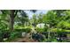 Landscaped backyard with greenhouse and various plants at 711 Sunset Ave, Orange City, FL 32763