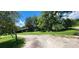 Gravel driveway leading to a rustic barn and additional structures at 711 Sunset Ave, Orange City, FL 32763