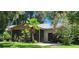 House exterior showcasing a screened porch and tropical landscaping at 711 Sunset Ave, Orange City, FL 32763