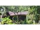 Home's back exterior, featuring a screened porch and lush surroundings at 711 Sunset Ave, Orange City, FL 32763