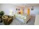 Bedroom with a white bed frame, tropical bedding, and an armchair at 4435 S Atlantic Ave # 414, Ponce Inlet, FL 32127