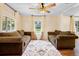 Living room with two brown sofas, wood floors, and ceiling fan at 409 W Beresford Ave, Deland, FL 32720