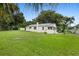 Large grassy backyard with mature trees and a detached building at 409 W Beresford Ave, Deland, FL 32720
