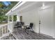 Covered front porch with three black chairs and a small table at 409 W Beresford Ave, Deland, FL 32720