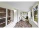 Bright screened porch with wicker furniture and wood-look flooring at 409 W Beresford Ave, Deland, FL 32720