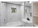 Clean bathroom with white vanity, tub shower combo and gray tile at 409 W Beresford Ave, Deland, FL 32720