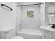 Updated bathroom with modern vanity, bathtub and gray tile at 409 W Beresford Ave, Deland, FL 32720