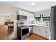 Modern kitchen with white cabinets, stainless steel appliances, and a window at 409 W Beresford Ave, Deland, FL 32720