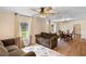 Living room with two brown sofas, wood floors, and ceiling fan at 409 W Beresford Ave, Deland, FL 32720