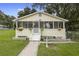Charming yellow house with a screened porch and landscaped lawn at 409 W Beresford Ave, Deland, FL 32720