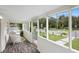 Bright screened porch with wicker furniture, wood-look flooring at 409 W Beresford Ave, Deland, FL 32720