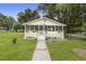 Charming yellow house with a screened porch and landscaped lawn at 409 W Beresford Ave, Deland, FL 32720