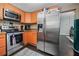 Modern kitchen with stainless steel appliances and orange cabinets at 112 S Chandler Ave, Deland, FL 32724