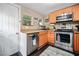Charming kitchen with orange cabinets, stainless steel appliances, and a tile backsplash at 112 S Chandler Ave, Deland, FL 32724