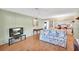 Living room with floral sofa, wood floors, and view to kitchen at 600 N Boundary Ave # 101A, Deland, FL 32720