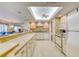 White kitchen with tiled floor and appliances at 1513 Ocean Shore Blvd # 3C, Ormond Beach, FL 32176