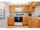 Efficient kitchen featuring wood cabinets, microwave, oven, and dishwasher at 4175 S Atlantic Ave # 1130, New Smyrna Beach, FL 32169