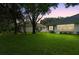Spacious backyard with lush green grass and mature trees surrounding the home at 1117 Athlone Way, Ormond Beach, FL 32174