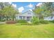 Charming light blue house with a porch and manicured lawn at 450 W Delaware Ave, Lake Helen, FL 32744