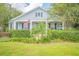 A light blue house with white trim, a porch, and lush landscaping at 450 W Delaware Ave, Lake Helen, FL 32744
