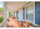 Spacious front porch with wicker furniture and potted plants at 450 W Delaware Ave, Lake Helen, FL 32744