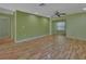 Bright living room featuring laminate wood floors and soft green walls at 13 Villa Villar # 0, Deland, FL 32724